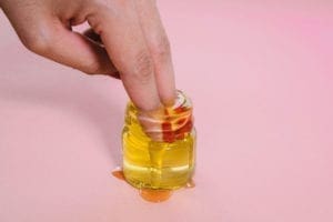 Finger tips in a small bottle of oil 