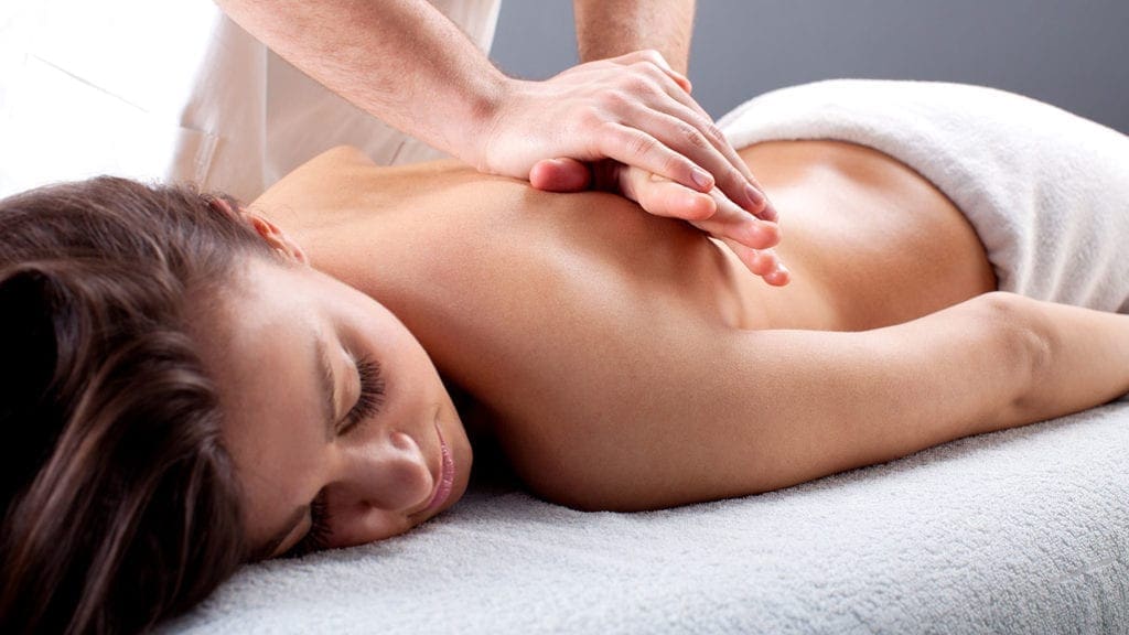 Man massaging woman's back during sensual body rub