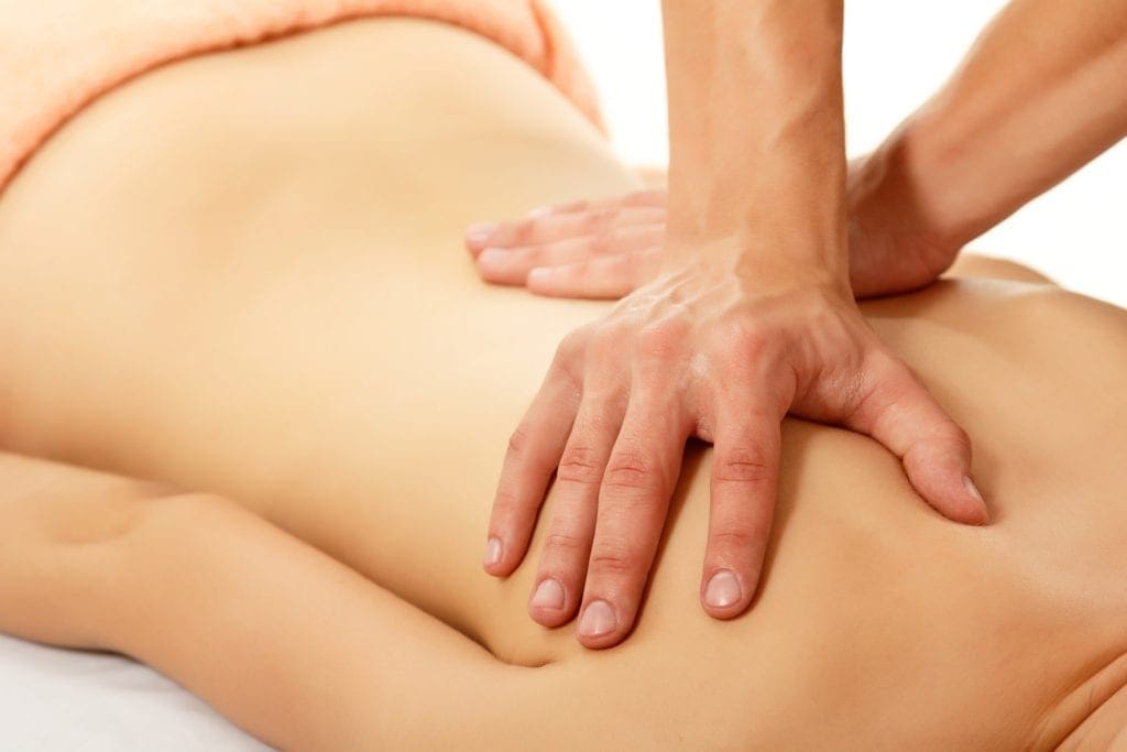Man massaging woman's back during sensual body rub